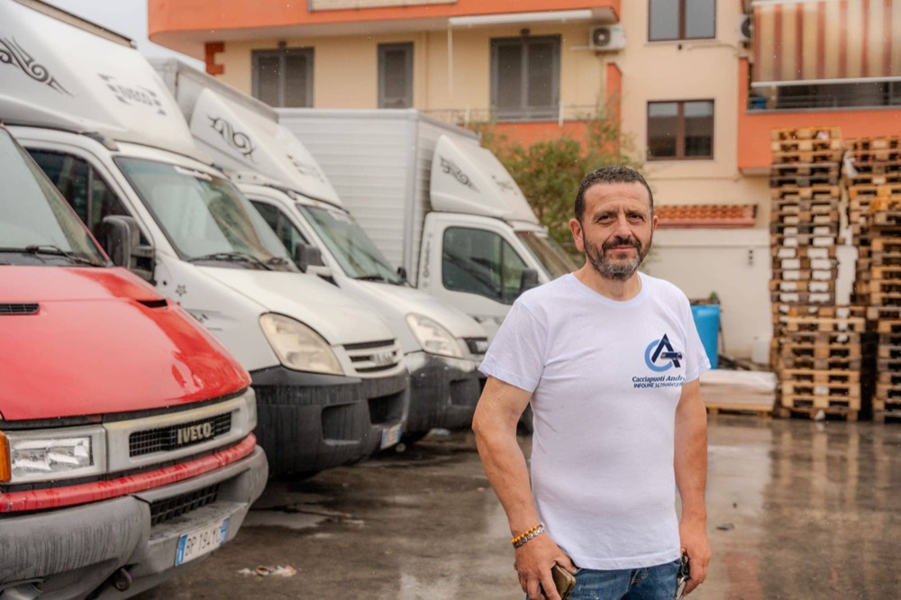 Andrea Cacciapuoti davanti ai mezzi dell'impresa, nel piazzale del deposito