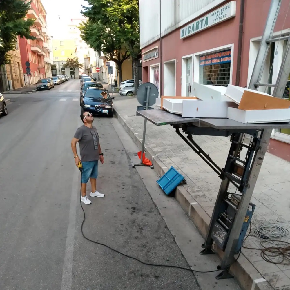 Un operatore controlla la scala montata in strada mentre i mobili salgono al piano